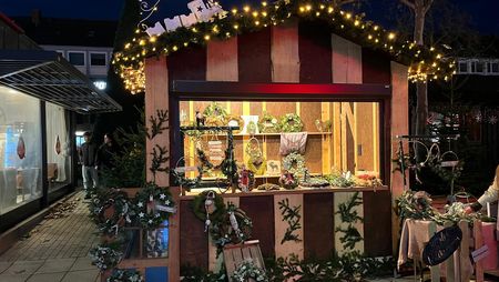 Eine weihnachtlich geschmückte Holzhütte mit Verkaufsausgabe.