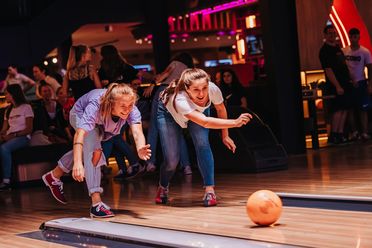 Zwei junge Frauen beim Bowling.